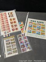 Photo of multiple plate block postage stamps pages in protective sleeves featuring various themes such as sports, historic figures, and kids care.
