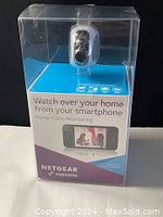 Front view of the camera packaging showing the Netgear Vuezona branding, product image, and smartphone monitoring feature highlights.