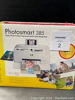 Original box of HP Photosmart 385 GoGo Photo Printer with printed photos shown on box.
