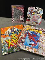 Photo showing all items in the lot, including Spider-Man decal, Spider-Man toy set in packaging, X-Men 'Look & Find' book, and Spider-Man comic book.