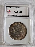 Front side of the encapsulated 1936 Canada silver dollar coin showing AU 58 grade and details