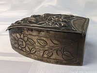 Side view of the antique silver snuff box showing floral engraved pattern along the side and hinge on back edge.