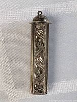 Front view of the antique sterling silver pendant showing the detailed carved floral design.