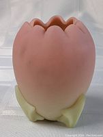 Front angled view of pink to yellow satin glass bud vase, scalloped flower petal shape at top, leaf-like base