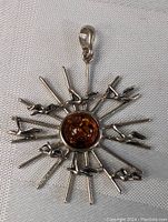 Full view of the sterling silver pendant with amber stone and bird motifs