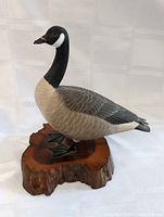 Side angle of the carved wood Canada Goose sculpture showing feather detail and wood base