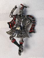 Close-up front view of vintage sterling silver Scottish dancer pin brooch with enamel details