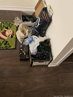 Overview of all items including boxes and bags of Christmas lights arranged on floor near doorway.