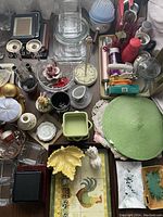 Various kitchen items including candlestick holders, glass bowls, ceramic vases, tissue paper rings, and a green woven placemat