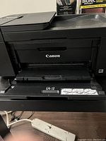 Close up of the Canon PIXMA printer front showing the paper output tray and Canon logo.
