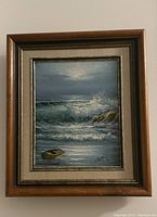 Frontal view of framed oil painting showing ocean scene with waves and boat