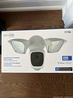 Box of Eco4Life SmartHome WiFi Floodlight Camera showing product image, branding, features including full 1080p resolution, 2500 lumens brightness, and voice assistant compatibility.