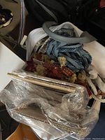 Box containing various Robert Allen trims and tassels, including braided cords and fabric trims in blue, white, and red shades.