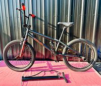 Full side view of Redline BMX bike showing frame, tires, seat, handlebars and tire pump in front.