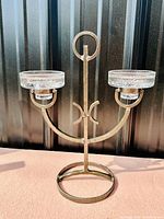 Photo of full candleholder showing hand hammered iron base with two clear glass votive holders on each arm.