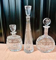 Three vintage lead crystal decanters arranged side by side showing size and design differences.
