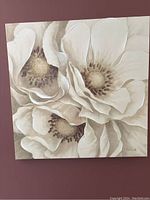 Full view of square floral canvas art showing three large flowers in neutral tones.