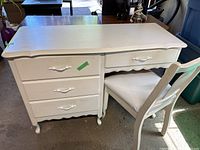 Full view of white ornate desk and matching cushioned chair showing overall shape and condition