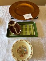 Top view showing all three items: raised charger plate in copper tone, Royal Doulton Bunnykins decorative plate, and football-themed chip and dip tray with chip bowl.