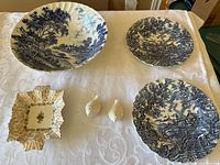 Top view of all items laid out on table: three Ridgway Ironstone plates, one small floral dish, and two bird salt and pepper shakers.