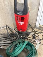 Power washer unit from front, showing brand and PSI rating with attached hoses.