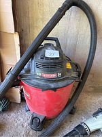 Front and top view of Craftsman shop vac displaying branding, motor information, and attached hose.