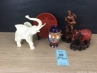 Image showing complete collection of Asian art objects including cinnabar plate, resin elephants, wood fisherman statue, and small vase with Japanese mark.