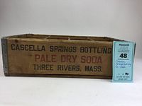 Front view of the wooden crate showing the black and red painted lettering: 'Cascella Springs Bottling Co. Pale Dry Soda Three Rivers, Mass.' The crate is wood with metal edges.