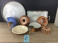 Photo showing full lot including copper molds, aluminum trays, pottery items, and vintage jars