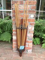 Front view of the drying rack with rods folded up showing the decorative wooden backboard and some worn rods.