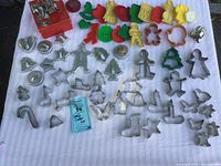 Wide view of all cookie cutters laid on fabric showing various metal and colorful plastic shapes.