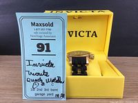Invicta Trinite watch displayed in yellow Invicta box with Maxsold lottery tag view.
