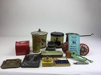 Overview photo showing all items including tins, trays, holders, and small tools arranged on a white background.