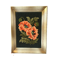 Full view of framed hooked rug wall art showing two orange poppies with green leaves on black background in wooden frame with metallic gold and ecru paint.