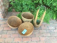 Overview of all four hanging baskets showing three round baskets and one taller basket with handle.