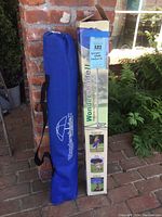 Wondershade II umbrella in blue carrying case next to original product box with branding and instructions visible.