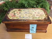 Top angle showing closed wooden sewing box with hand-painted flower design on lid.