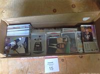Cardboard box filled with various hockey and other sports cards in loose condition, some in plastic sleeves.