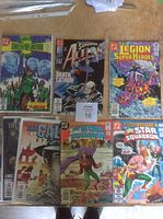 Photo showing six comic books laid out on a table: Green Lantern, Action Comics, Legion of Super-Heroes, The Call, and two All-Star Squadron issues.