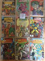 Photo showing 9 vintage comic books including Howling Commandos, Star Squadron, Mystery in Space