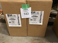 Two unopened cardboard boxes labeled Franmar Bean-e-doo Asphalt Cleaner, product details visible on front labels.