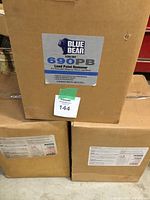 Three cardboard boxes labeled Blue Bear 690PB Lead Paint Remover, stacked in a warehouse.