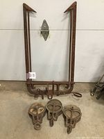 Hay fork and three pulley blocks arranged on concrete floor against a white door background, showing the overall lot contents.