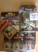 Various hockey collectibles including small figures in packaging and two hockey books