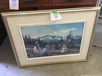 Full view of the framed print depicting children sitting on grass with a rustic cabin and mountains in the background.