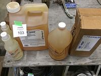 All items of Soy Strip marine paint stripper set including large jug, smaller bottles and carton box shown on wooden surface.