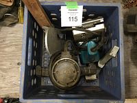Blue plastic milk crate containing a Black & Decker router and a blue Makita orbital palm sander with their cords.