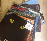 Photo of vinyl album covers showing artists Ray Charles, Willie Nelson, Burton Cummings, Mr. Mister, and others, with normal wear on covers.