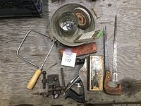 Top down image showing the entire lot including saws, clamp, planer box, and various small tools on a workbench surface.