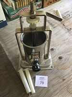 Front angled view of manual sausage stuffer showing stainless steel cylinder, crank handle, and gear mechanism.